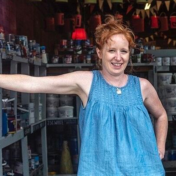 A red haired woman stood in a workshop